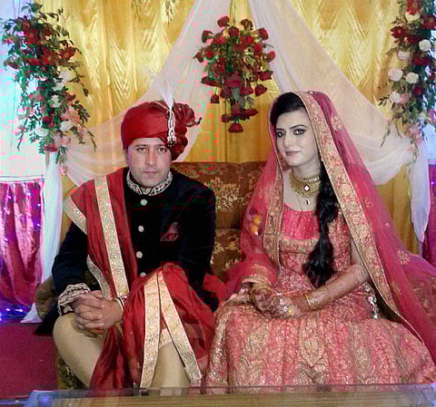 A sub inspector in Jammu and Kashmir Police with his bride from Pakistan-occupied Kashmir at their wedding function in Srinagar. (PTI)