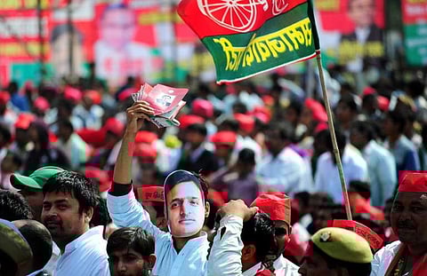This file photograph taken on March 2, 2014, shows a supporter of India's Samajwadi Party wearing a mask of Uttar Pradesh Chief Minister Akhilesh Yadav during a public rally | AFP