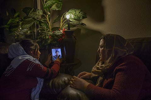 In this Dec. 1, 2016, photo, Maryam Rafi, 13, steadies an iPad as her uncle and Malalai Rafi's brother Zakir Noori explain his second visa to come to the U.S. from Afghanistan was denied in Sacramento, Calif. | AP