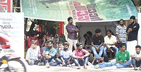Students of Maharaja's College staging a hunger strike in front of the college gate on Monday | melton antony