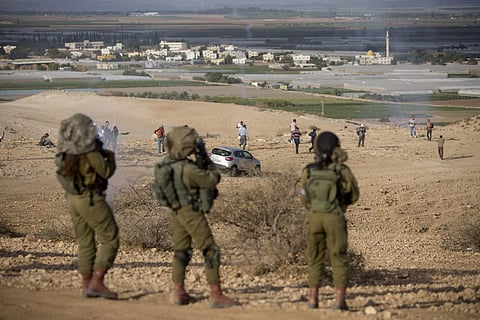 In this Nov. 17, 2016 file photo, Palestinians and Israeli activists run away from a tear gas fired by Israeli soldiers during a demonstration against the construction of Jewish settlements in the Jordan Valley, in the West Bank, Thursday, Nov. 17, 2016.