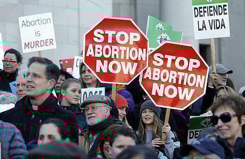 Participants in an anti-abortion rally hold signs that read 'Stop Abortion Now' as they listen to speakers on January 23 in Washington. (Photo | AP)