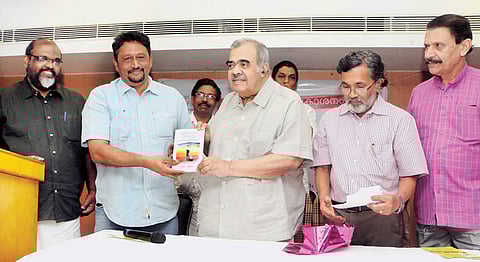 Former Union Minister K P Unnikrishnan handing over the new book ‘Spectrum of Polity’ written by C P John to The New Indian Express Resident Editor Vinod Mathew Jacob at the book release function held at East Avenue in Kozhikode on Saturday | T P Soora