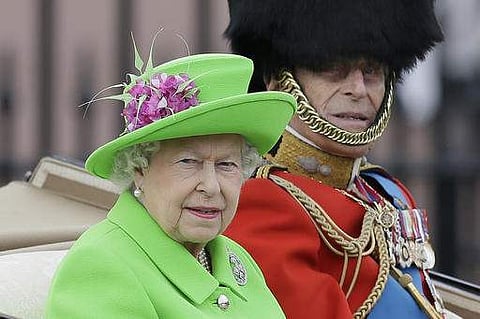 In this file photo, Britain's Queen Elizabeth and Prince Philip ride in a carriage during the Trooping The Colour parade at Buckingham Palace in London.