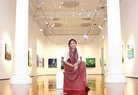 Fathima Hakkim with her paintings at Durbar Hall art gallery