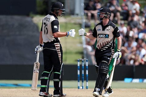 Colin Munro (R) and Tom Bruce of New Zealand celebrate a boundary during the 20/20 International between New Zealand and Bangladesh at Bay Oval in Mount Maunganui. | AFP