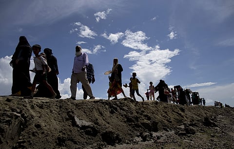 FILE - In this Oct. 2, 2017, photo, newly arrived Rohingya Muslims from Myanmar walk as they continue their journey in to a camp for refugees in Teknaf, Bangladesh. | AP