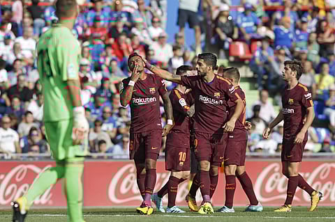 Barcelona's Paulinho, left, celebrates with teammate Luis Suarez after scoring against Getafe during a Spanish La Liga soccer match between Getafe and Barcelona. | AP