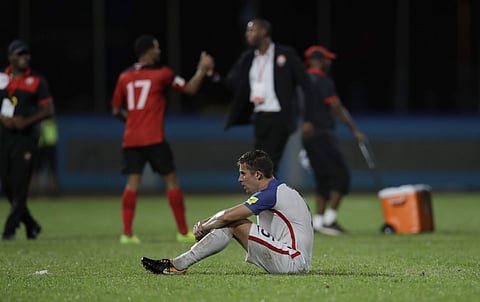 United States' Matt Besler, squats on the pitch after losing 2-1 against Trinidad and Tobago during a 2018 World Cup qualifying soccer match in Couva, Trinidad, Tuesday, Oct. 10, 2017. | AP