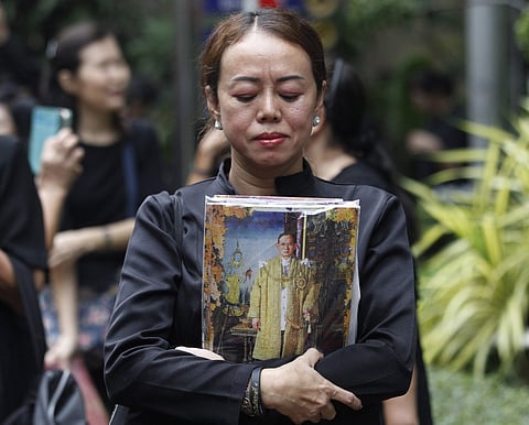 Thai mourner holds a portrait of the late Thai King Bhumibol Adulyadej at Siriraj Hospital where he died in Bangkok, Thailand, Friday, Oct. 13, 2017. | AP
