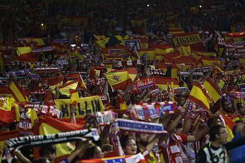 Atletico Madrid supporters hold up Spanish flags during a Spanish La Liga soccer match between Atletico Madrid and Barcelona at the Metropolitano stadium. | AP