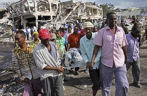 Somalis remove the body of a man killed in Saturday's blast in Mogadishu. (Photo | AP)