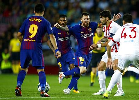 Barcelona's Lionel Messi, center, plays with teammate Luis Suarez, left, during the group D Champions League soccer match against Olympiakos. | AP