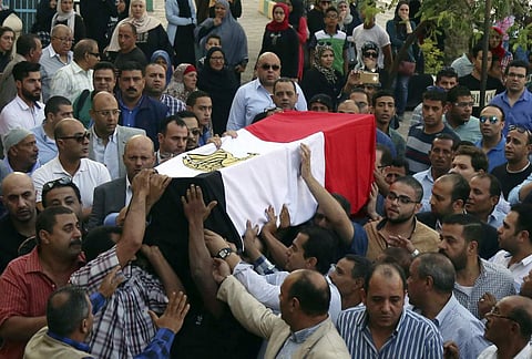 People carry the coffin, covered with the an Egyptian flag, of police captain Ahmed Fayez who was killed in a gun battle. (Photo | AP)