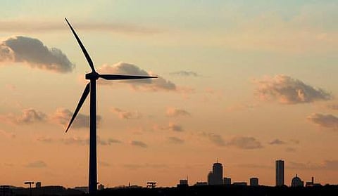 a wind turbine stands, generating power next to Hull, Mass.|AP