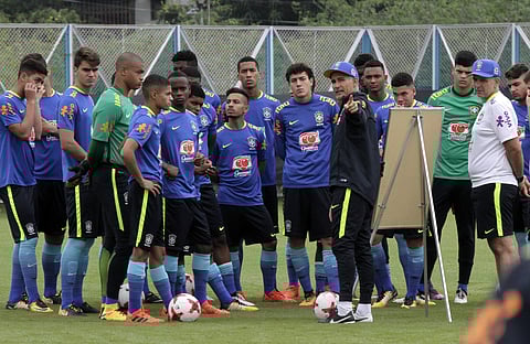 Brazilian coach Carlos Amadeu Nascimento Lemos, beside the board, gives pointers to his players during a training session. | AP