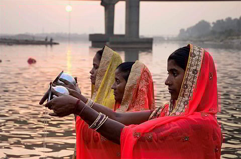 Devotees perform rituals during sunset at the Tawi river on the occasion of Chhath festival in Jammu on Thursday. (Photo | PTI)