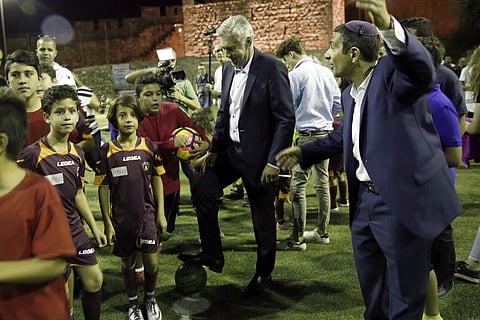 Italian soccer coach Carlo Ancelotti stand with Muslim, Christian and Jewish youth as part of the Assist for Peace, a coexistence group, in Jerusalem Monday, Oct. 2, 2017. | AP