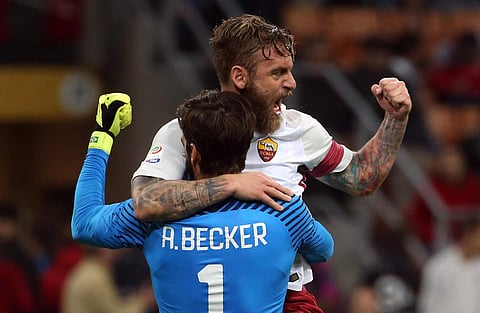 Roma goalkeeper Alisson Becker and teammate Daniele De Rossi celebrate their side's 2-0 win at the end of the Serie A soccer match between AC Milan and Roma, at the Milan San Siro stadium. | AP