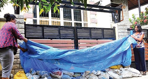 Meena Gupta and her daughter place sand bags near their HSR Layout residence’s gate | Pushkar V