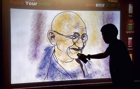 A child digitally paints on a portrait of Mahatma Gandhi displayed at a digital exhibition called Uniting India - Sardar Patel at Visvesvaraya Industrial and Technological Museum in Bengaluru. (Epress Photo | Vinod Kumar)