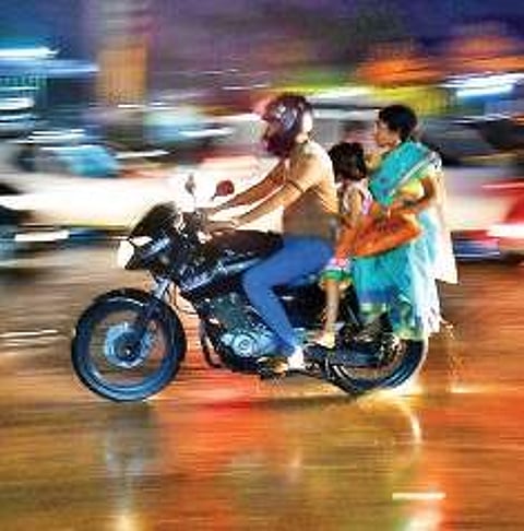 A family braves the showers at Ambattur Estate on Sunday | P JAWAHAR