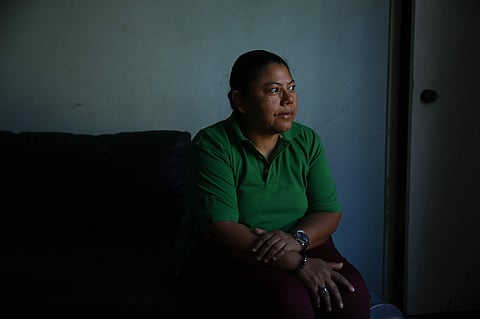 Iris Acosta, a 51-year-old hotel housekeeper from Honduras, pauses for photos in her sister's apartment in Los Angeles. (Photo | AP)