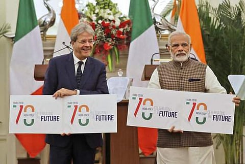Indian Prime Minister Narendra Modi, right, with his Italian counterpart Paolo Gentiloni release a plan card celebrating 70 years of India Italy diplomatic relations in New Delhi. | AP