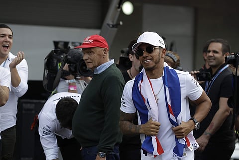 Mercedes driver Lewis Hamilton, of Britain, runs by three-time F1 World Drivers' Champion Nikki Laura, from Austria, as he arrives to celebrate with members of his team at the pit lane after the Formula One Mexico Grand Prix auto race at the Hermanos Rodr