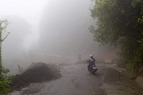 Neighbors walk under the rain past a washed out road in Alajuelita on the outskirts of San Jose. (Photo | AP)