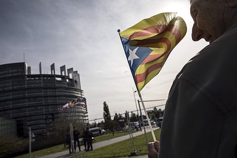 A demonstrator waves a Catalan flag in support of the disputed independence vote Sunday in Catalonia. (Photo | AP)