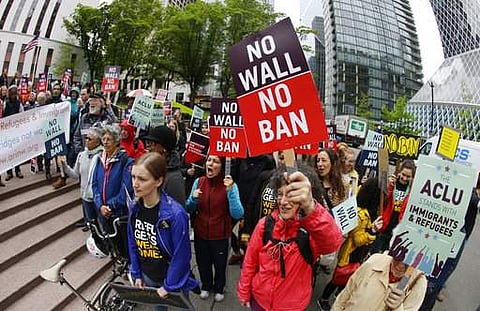 protesters wave signs and chant during a demonstration against President Donald Trump's revised travel ban outside a federal courthouse in Seattle. (Photo | AP)