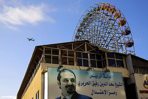 A poster of outgoing Prime Minister Saad Hariri hangs on a building with Arabic words that read, 'Prime Minister Saad Hariri is a Symbol of moderation,' in Beirut, Lebanon. | AP