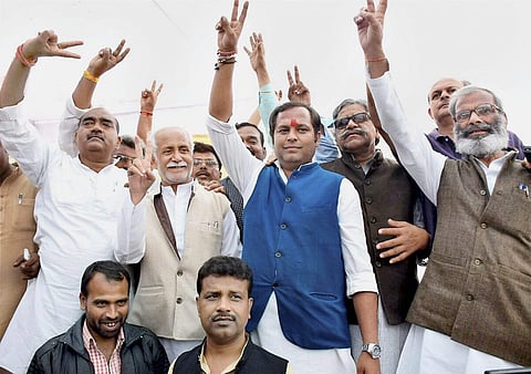 Congress candidate Neelanshu Chaturvedi blue jacket flashes victory sign after winning Chitrakoot state assembly by-election in Chitrakoot Madhya Pradesh on Sunday. | PTI