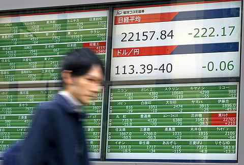 A man walks past an electronic stock board showing Japan's Nikkei 225 index, top, and exchanging rate between U.S. dollar and Japanese yen at a securities firm in Tokyo Wednesday, Nov. 15, 2017. (Photo | Associated Press)