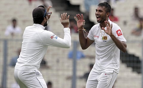 Sri Lanka's Dasun Shanaka, right, celebrates with captain Dinesh Chandimal the dismissal of India's Ravichandran Ashwin during the second day of their first test cricket match in Kolkata. | AP