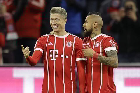Bayern's Robert Lewandowski, left, celebrates with team mate Arturo Vidal after scoring his side's third goal during the Bundesliga match against FC Augsburg. | AP