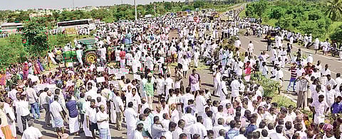 Farmers staging a road blockade protest seeking the release of water from Vaigai Dam on the Madurai-Kanniyakumari four-lane highway near Melur in Madurai on Monday | express