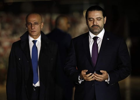 Lebanese Prime Minister Saad Hariri, right, prays over his father's grave, upon his arrival to Beirut, Lebanon, Tuesday, Nov. 21, 2017(AP)