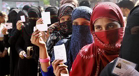 Burqa-clad voters wait to cast their votes for local body elections at a polling station in Meerut on Wednesday. | PTI