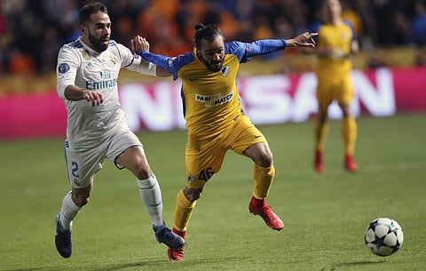 Real Madrid's Daniel Carvajal, left, APOEL's Efstathios Aloneftis challenge for the ball during the Champions League Group H soccer match between APOEL Nicosia and Real Madrid at GSP stadium. | AP