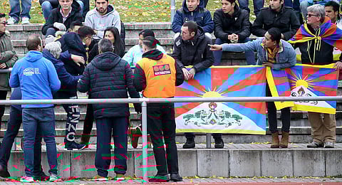 In this Nov. 18, 2017 file photo a Chinese spectator attempts to tear away a Tibetian flag which was raised by others in protest of China's politics regarding Tibet at the friendly match between TSV Schott Mainz and China's U20 team at the regional sports