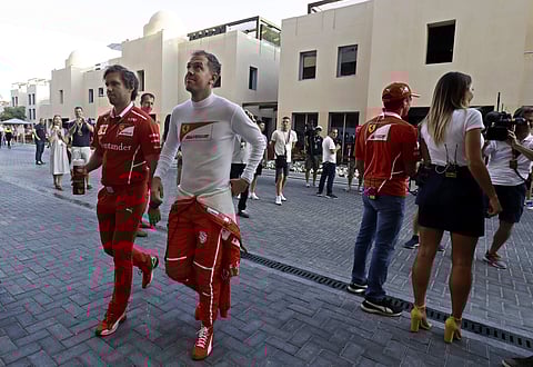 Ferrari driver Sebastian Vettel of Germany (C) walks in the paddock before the second free practice | AP