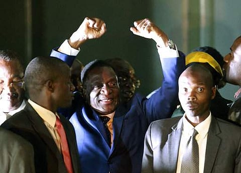 Emmerson Mnangagwa, centre, gestures as he greets the crowd upon arrival at the Zanu PF Headquarters in Harare.| AP