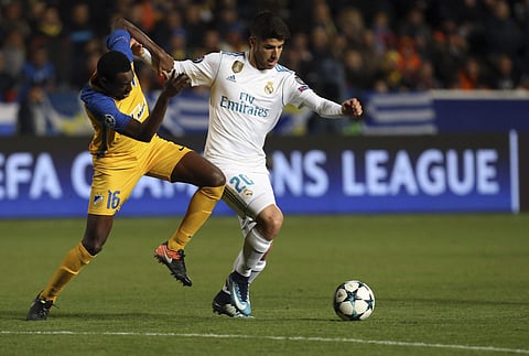 Real Madrid's Marco Asensio, right, and APOEL's Vinicius challenge for the ball during the Champions League Group H soccer match between APOEL Nicosia and Real Madrid at GSP stadium. | AP