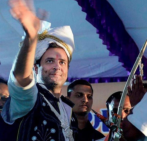 Congress Vice President Rahul Gandhi wearing a traditional dress waves at an election campaign rally in Dahod Gujarat on Saturday. | PTI