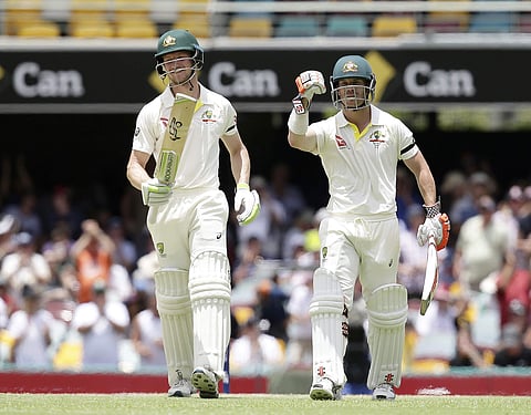 Australia's David Warner, right, and Cameron Bancroft walk off the field after winning the match against England during their Ashes cricket test in Brisbane, Australia, Monday, Nov. 27, 2017. | AP