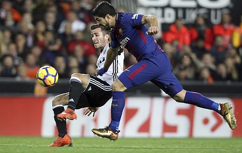 Barcelona's Luis Suarez, right , Valencia's Jose Luis Gaya, left, during the Spanish La Liga soccer match between Valencia and FC Barcelona at the Mestalla stadium in Valencia, Spain, Sunday, Nov. 26, 2017. | AP