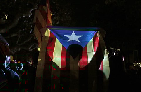 A man holds a 'Estelada', the pro-independence Catalan flag, as demonstrators gather outside the Catalonian Parliament to protest against the decision of a judge to jail ex-members of the Catalan government, in Barcelona, Spain, Thursday, Nov. 2, 2017. (P