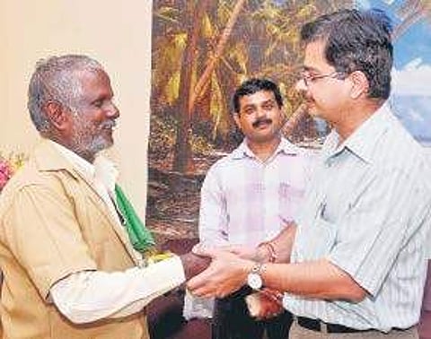 Chennai Divisional Railway Manager Naveen Gulati presenting the memento as token of appreciation to porter Poyyamozhi at Tambaram Railway Station on Wednesday | Express